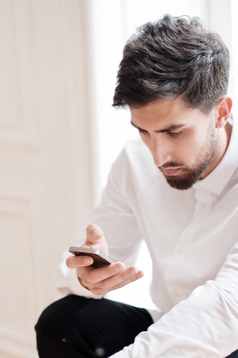 mobile responsive website; Man looking at smartphone